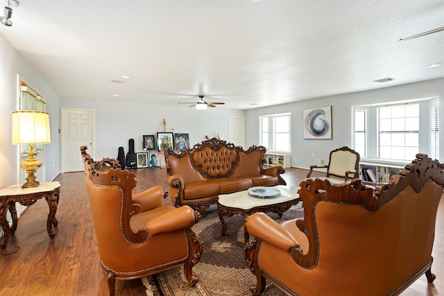 living room with hardwood / wood-style flooring, a wealth of natural light, ceiling fan, and a textured ceiling