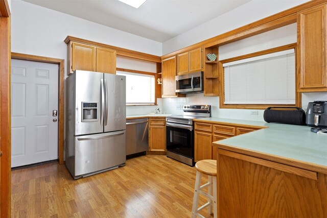 kitchen featuring ceiling fan, a kitchen island, stainless steel gas stovetop, island exhaust hood, and light hardwood / wood-style flooring