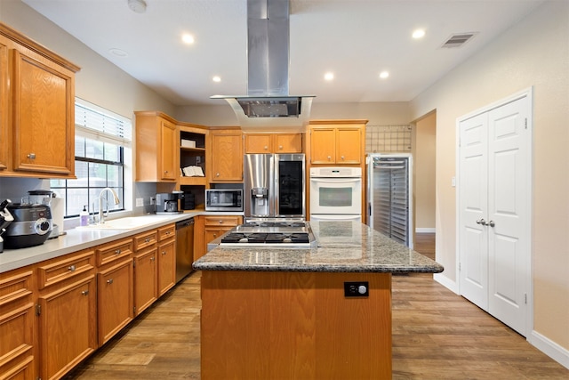 kitchen with hardwood / wood-style flooring, stainless steel appliances, a center island, and island range hood