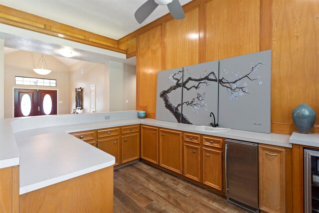 kitchen featuring decorative light fixtures, dark wood-type flooring, kitchen peninsula, sink, and ceiling fan