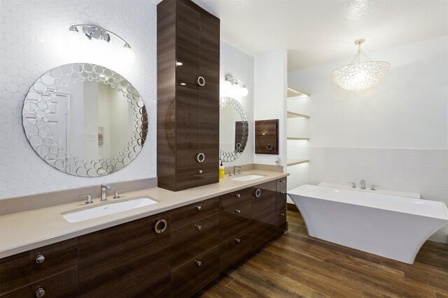 bathroom with hardwood / wood-style flooring, dual vanity, and a bathtub