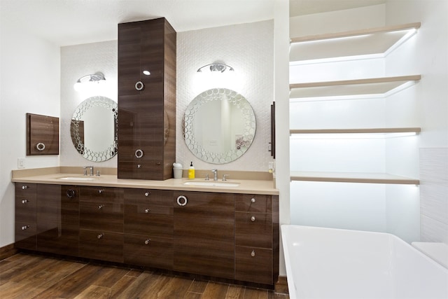 bathroom with wood-type flooring, a tub, and dual vanity