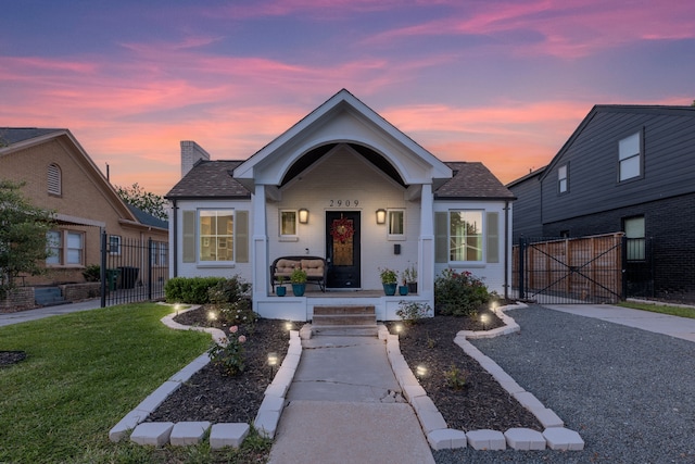 view of front of house featuring covered porch and a yard