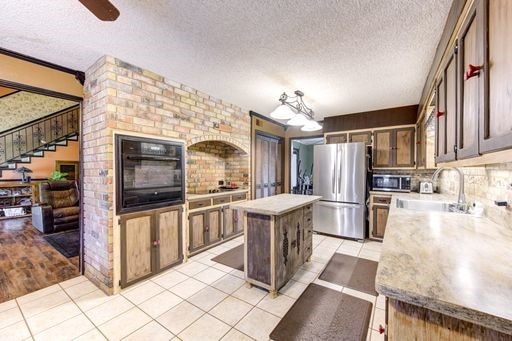 kitchen featuring a center island, light wood-type flooring, stainless steel appliances, sink, and ceiling fan