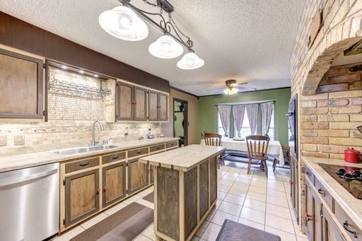 kitchen featuring ceiling fan, a center island, sink, dishwasher, and tasteful backsplash