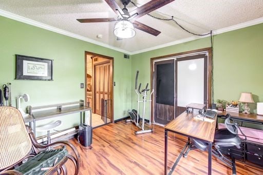 office with hardwood / wood-style floors, ceiling fan, crown molding, and a textured ceiling