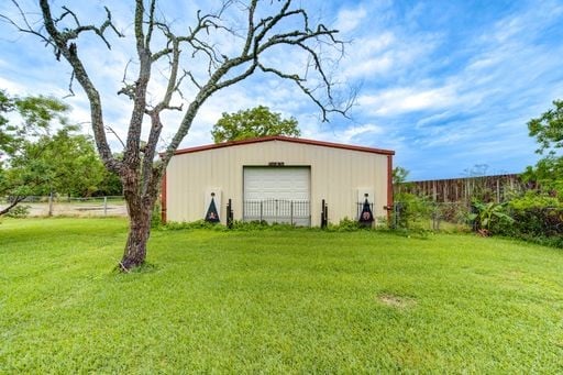 view of outdoor structure featuring a garage and a yard