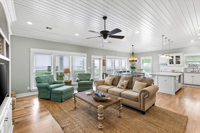 living room with wooden ceiling, ceiling fan with notable chandelier, and light wood-type flooring