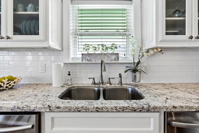 kitchen with white cabinets, sink, and backsplash