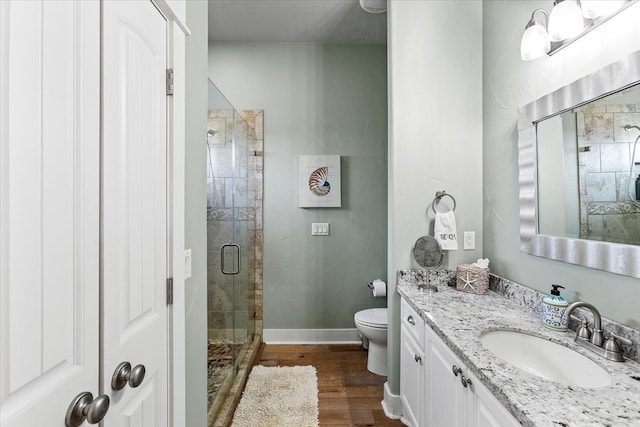 bathroom featuring a shower with door, toilet, oversized vanity, and hardwood / wood-style floors