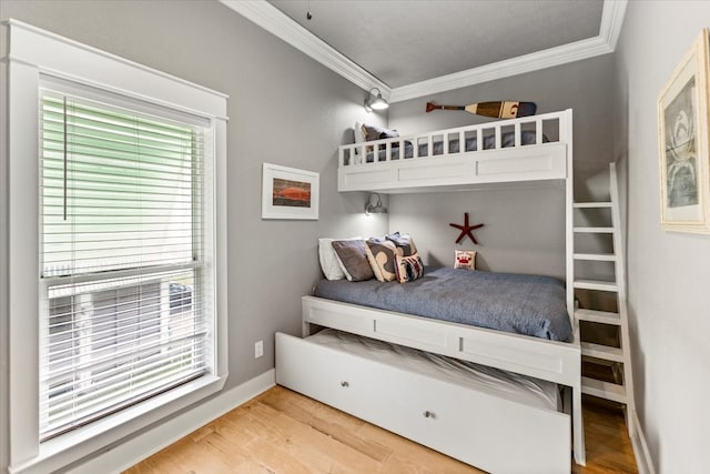 bedroom with light hardwood / wood-style flooring and crown molding