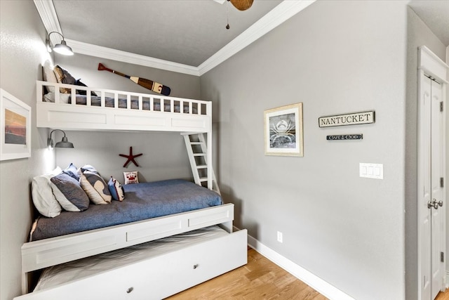 bedroom featuring ceiling fan, light hardwood / wood-style floors, and crown molding