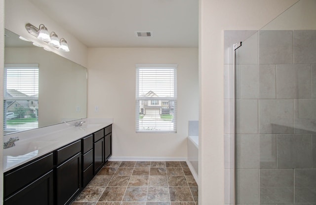 bathroom featuring double vanity, tile flooring, plenty of natural light, and a tub