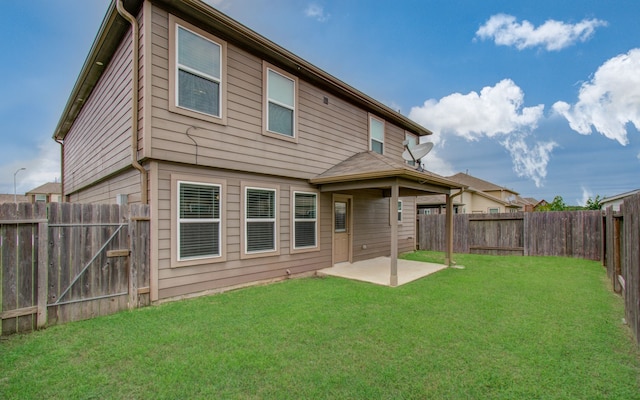 rear view of house featuring a patio area and a yard