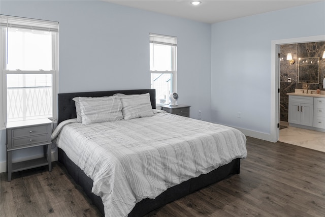 bedroom featuring connected bathroom and dark hardwood / wood-style floors