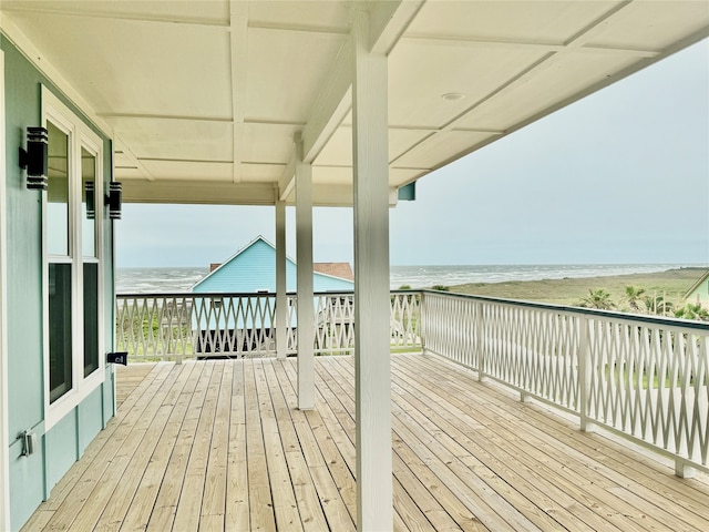 deck with a view of the beach and a water view