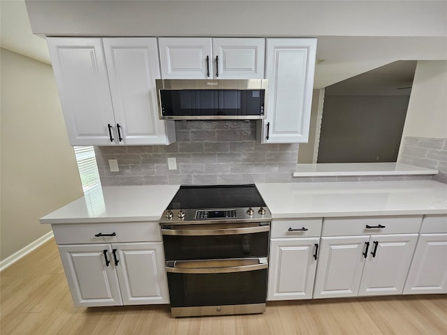 kitchen featuring white cabinetry, backsplash, and appliances with stainless steel finishes