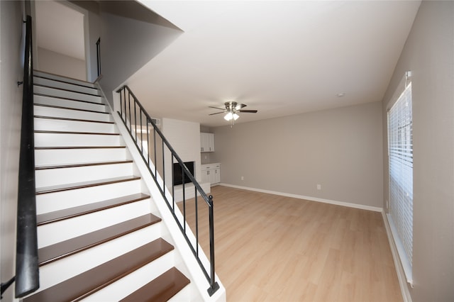 staircase featuring hardwood / wood-style floors and ceiling fan