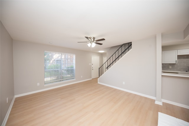 unfurnished living room featuring light hardwood / wood-style flooring and ceiling fan