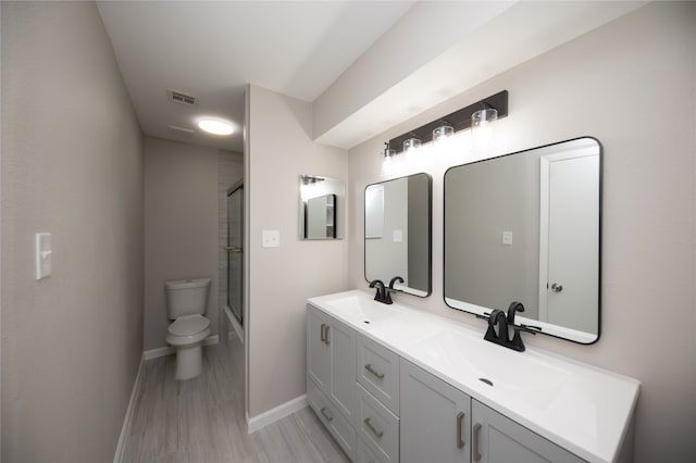 full bathroom with combined bath / shower with glass door, toilet, wood-type flooring, and vanity