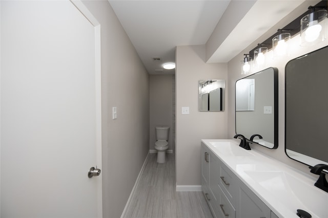 bathroom featuring hardwood / wood-style floors, vanity, and toilet