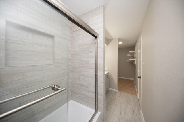 bathroom with hardwood / wood-style floors, vanity, and an enclosed shower