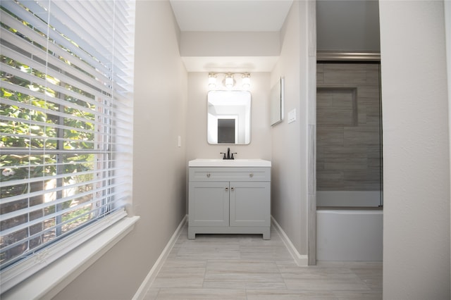 bathroom featuring tile patterned flooring, vanity, and tiled shower / bath