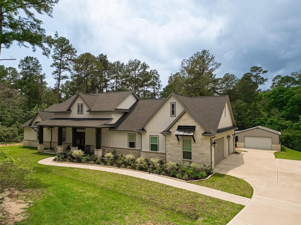 view of front of home with a garage, covered porch, and a front lawn