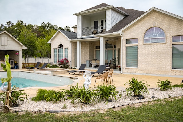 back of house featuring a fenced in pool, a patio, and a balcony