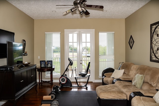 living room featuring dark hardwood / wood-style flooring, ceiling fan, french doors, and a textured ceiling