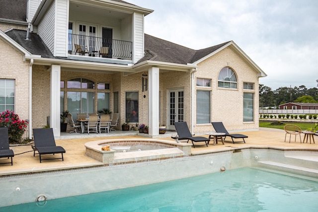 view of pool with a patio area and an in ground hot tub