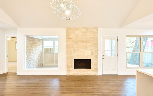 15830 Whipple Tree Dr, Houston, TX 77070 - unfurnished living room featuring vaulted ceiling, wood finished floors, a fireplace, baseboards, and cooling unit