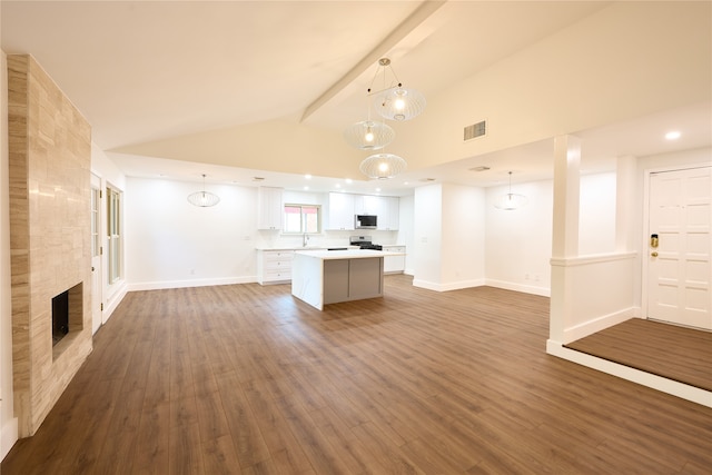 unfurnished living room featuring sink, hardwood / wood-style floors, vaulted ceiling with beams, and a fireplace