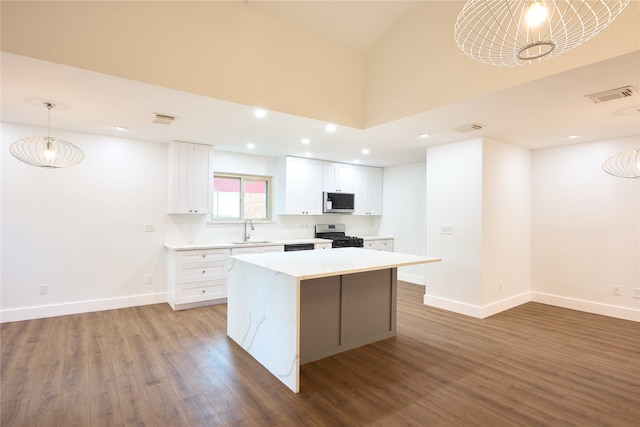 kitchen with stainless steel appliances, dark hardwood / wood-style flooring, a center island, white cabinets, and hanging light fixtures