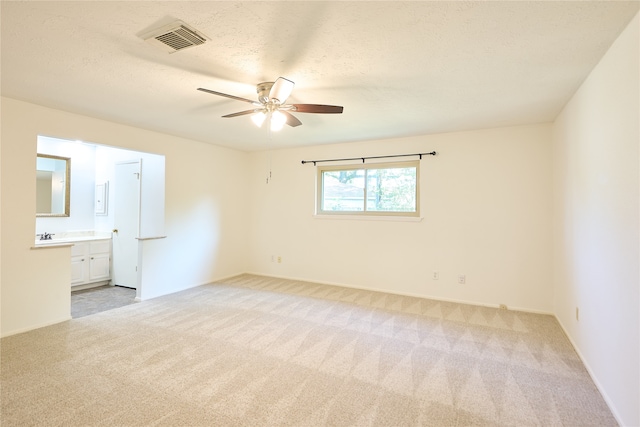 unfurnished bedroom with ceiling fan, connected bathroom, and light colored carpet