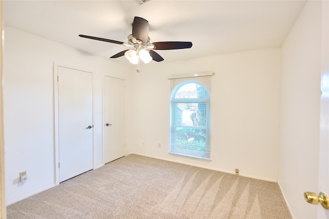 empty room with ceiling fan and light colored carpet