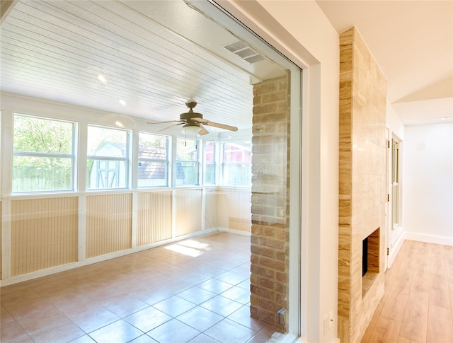 unfurnished sunroom with ceiling fan and wood ceiling