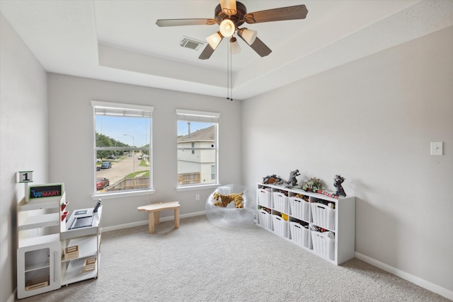 game room with ceiling fan, carpet, and a raised ceiling