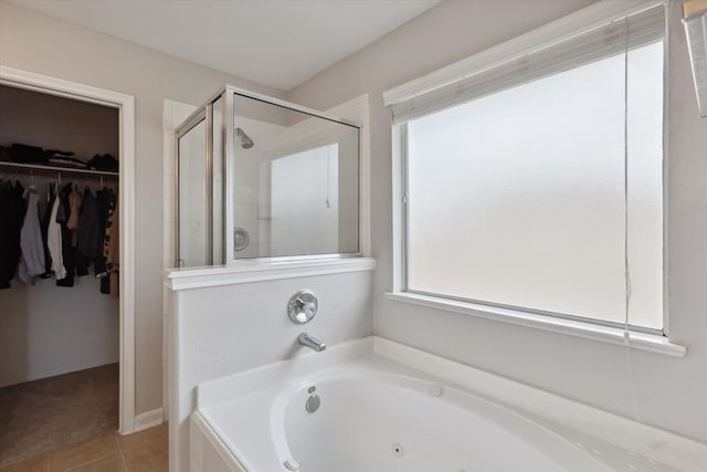 bathroom featuring shower with separate bathtub and tile floors