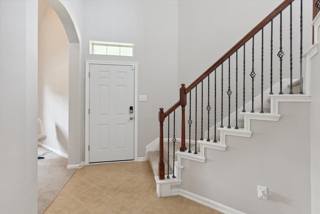 entrance foyer featuring a towering ceiling and light tile floors