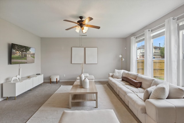 carpeted living room with ceiling fan