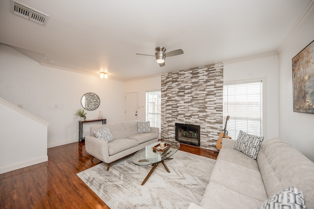 living room with a fireplace, wood-type flooring, a wealth of natural light, and crown molding