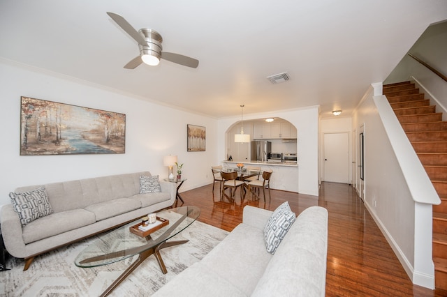 living room with dark hardwood / wood-style floors, ceiling fan, and crown molding