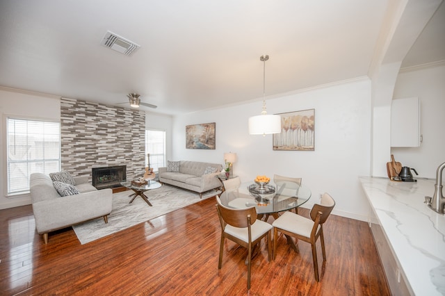 dining space with a tile fireplace, dark hardwood / wood-style flooring, and plenty of natural light