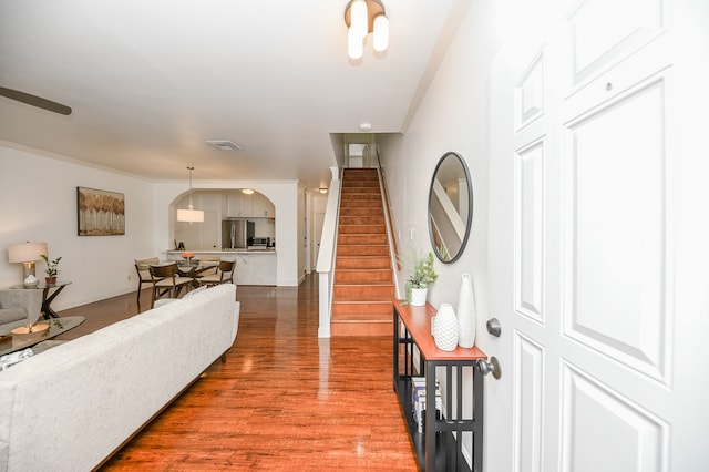 living room featuring wood-type flooring and crown molding