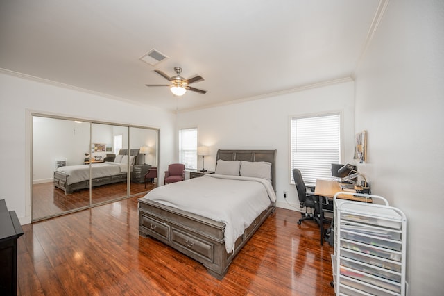 bedroom featuring ceiling fan, dark hardwood / wood-style flooring, crown molding, and a closet