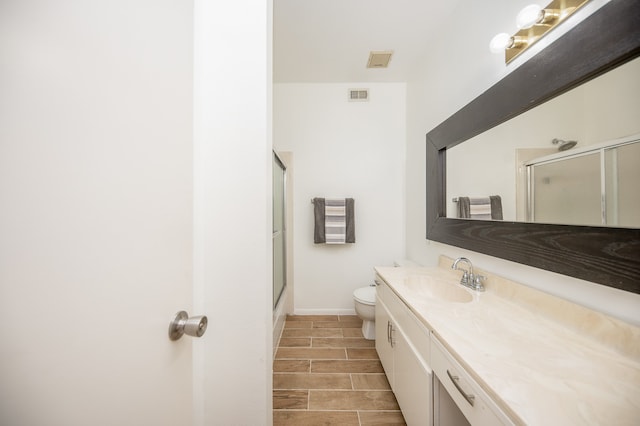 full bathroom featuring vanity, toilet, and shower / bath combination with glass door