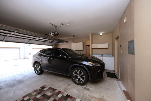 garage with electric panel, a garage door opener, and washing machine and clothes dryer