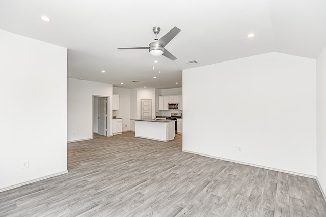 unfurnished living room featuring ceiling fan, sink, and light wood-type flooring