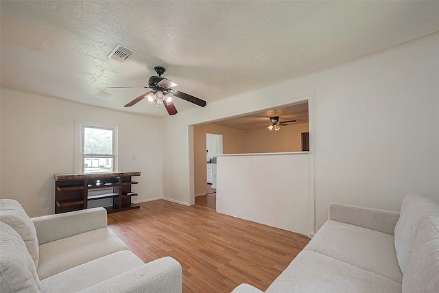 living room featuring light hardwood / wood-style flooring and ceiling fan